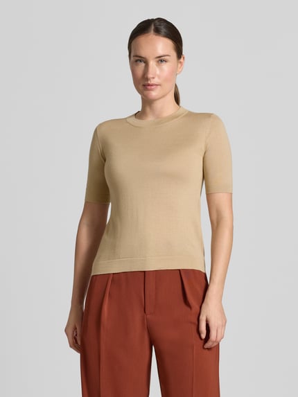 Frauenmodel trägt Regular Fit Pullover aus Woll-Seiden-Kaschmir-Mix Modell 'TAPIOCA' von Weekend Max Mara in Beige mit glatter Textur, Kombi mit rostfarbenen Hosen, Ganzkörperansicht von vorne, Damen Pullover von Max Mara.