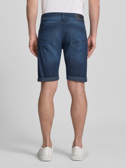 Männermodel trägt Jeansshorts mit Label-Detail von Pierre Cardin, Blau, Baumwoll-Mix, Regular Fit, Umschlag, Ganzkörperansicht Rückansicht.