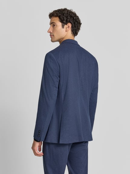 Männermodel trägt fein strukturiertes Slim Fit 2-Knopf-Sakko Modell 'Michel' von Pierre Cardin in Dunkelblau, Ganzkörperansicht Rückansicht. Material-Mix mit Viskose-Anteil, Reverskragen, aufgesetzte Taschen.