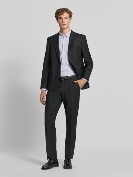 Männermodel trägt Slim Fit Businesshemd aus reiner Baumwolle Modell 'New B.D.' von Seidensticker, dunkler Anzug, Ganzkörperansicht von vorne, Herren Businesshemd von Seidensticker.