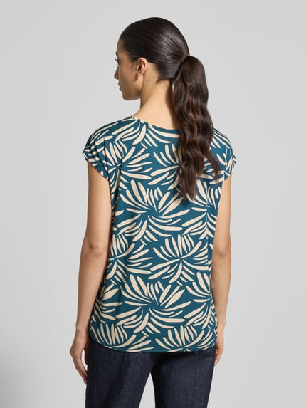 Vrouwenmodel draagt Regular fit blouse uit viscosemix model 'Minou' van ZABAIONE met all-over bloemenmotief, korte mouw, ronde hals, elastische band, ruglengte bij maat S 62 cm, rugaanzicht.