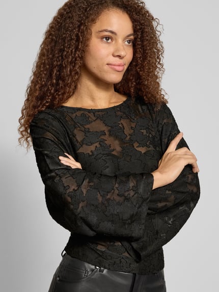 Frauenmodel trägt Langarmshirt mit Mesh Ausbrenner-Effekt von ONLY, schwarzer Spitzenlook, Rundhals, ausgestellte Ärmel, Nahaufnahme Oberkörper.