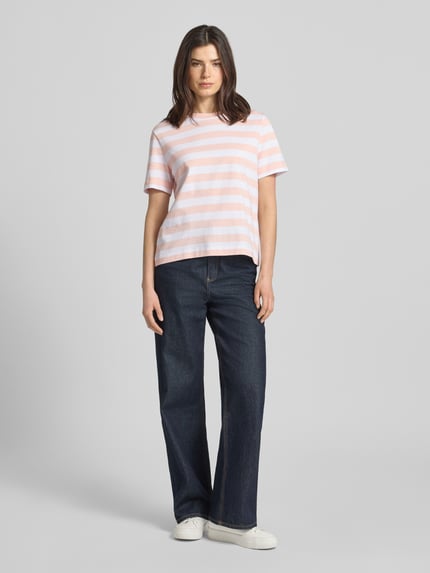 Frauenmodel trägt Boxy Fit T-Shirt aus reiner Baumwolle Modell 'ESSENTIAL' von Selected Femme mit Optik:Allover-Muster, gestreift, Label-Patch, Rundhals, Kurzarm, heavy Jersey, in Rosa-Weiß, Ganzkörperansicht von vorne.