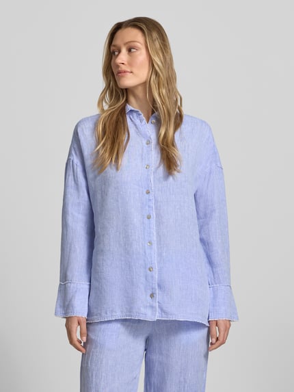 Frauenmodel trägt Regular Fit Hemdbluse aus reinen Leinen von Christian Berg Woman in Hellblau mit Hemdblusenkragen, durchgehender Knopfleiste, Langärmelig, Fransenbesatz, strukturierte Leinen-Oberfläche, Rückenlänge 72 cm, Ärmellänge 55 cm, Ganzkörperansicht von vorne.