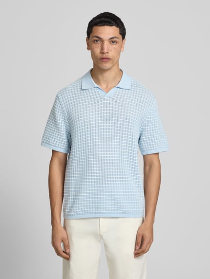 Männermodel trägt Regular Fit Poloshirt mit V-Ausschnitt von Jack & Jones aus reiner Baumwolle im Strickshirt-Stil, Ganzkörperansicht von vorne.