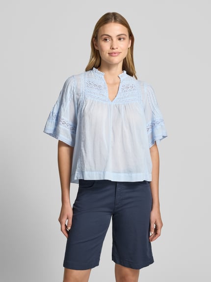 Vrouwenmodel draagt lichtblauwe Bluse met Häkelspitze Modell 'Siama' van Neo Noir, loose fit, Serafino-kraag, 1/2-mouw, katoen, vooraanzicht bovenlichaam.