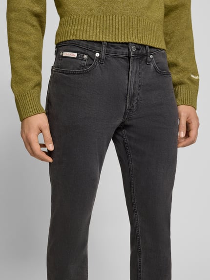 Männermodel trägt Slim Fit Jeans mit Label-Detail von Calvin Klein Jeans, Baumwoll-Elasthan-Mix, Knopf- und Reißverschluss, Eingrifftaschen, Nahaufnahme Oberkörper