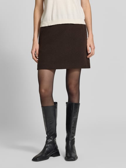 Frauenmodel trägt Minirock mit elastischem Bund Modell 'WOLCA' von ICHI, dunkelbraun, A-Linie, Struktur-Muster, Ganzkörperansicht von vorne.