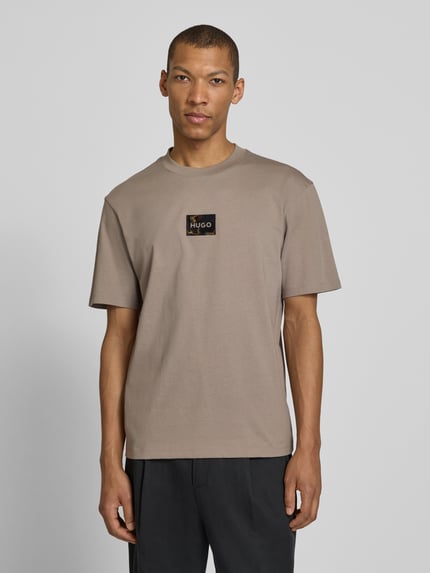 Männermodel trägt Regular Fit T-Shirt aus reiner Baumwolle Modell 'DUMEON' von HUGO, Optik: Unifarben, Label-Applikation, Rundhals, Kurzarm, Materialverarbeitung: Jersey, Ganzkörperansicht von vorne.