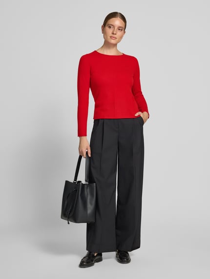 Frauenmodel trägt Regular Fit Strickpullover aus reinem Kaschmir von Christian Berg Woman in Rot mit Ziernaht und Rundhalsausschnitt, Ganzkörperansicht von vorne.