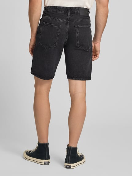 Männermodel trägt Straight Leg Jeansshorts aus reiner Baumwolle Modell 'EDGE' von Only & Sons in Denim-Optik, Label-Patch, 5-Pocket-Design, Ganzkörperansicht Rückansicht.