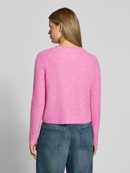 Frauenmodel trägt Cardigan mit Label-Patch von ONLY in Rosa, Strickoptik, gerippte Abschlüsse, unifarben, Ganzkörperansicht Rückansicht.
