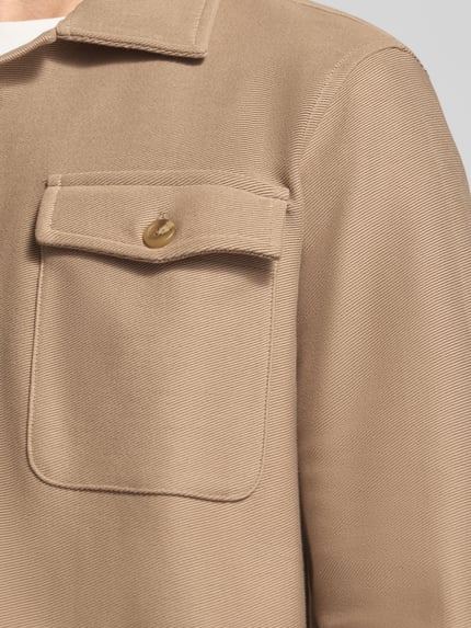 Männermodel trägt Regular Fit Hemdjacke aus reiner Bio-Baumwolle Modell 'OLIVER' von SELECTED HOMME, Nahaufnahme Oberkörper. Optik: Unifarben, Passform: Regular-Fit, Kragenform: Umlegekragen, Verschluss: einreihige Knopfleiste, Applikation: Label-Stitching, Ärmelform: Langarm, Ärmelabschluss: Manschette, Taschen: Brusttaschen, Material: reine Bio-Baumwolle.