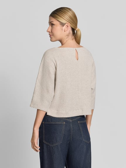 Frauenmodel trägt Loose Fit Pullover mit Baumwoll-Anteil Modell 'Sassoni' von OPUS in Creme mit feiner Struktur, Ganzkörperansicht Rückansicht.