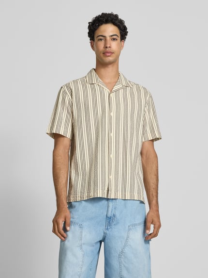 Männermodel draagt Relaxed Fit vrijetijdsoverhemd uit puur katoen model 'CRUZ' van Only & Sons met streepmotief, resortkraag, doorlopende knoopsluiting, achterpas, korte mouw en seersucker materiaalverwerking, frontale volledige lichaamsweergave.