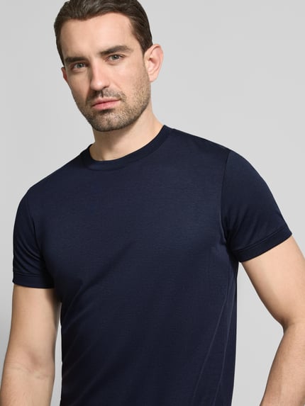 Männermodel trägt T-Shirt mit Rundhalsausschnitt von RAGMAN aus Reine Baumwolle, Slim-Fit, Unifarbenes-Design, Nahaufnahme Oberkörper.