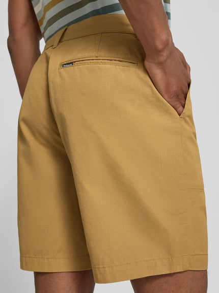 Männermodel trägt Regular Fit Chinoshorts aus reiner Baumwolle Modell 'SHERBURN' von Barbour, sandfarben, Herren, Ganzkörperansicht Rückansicht.