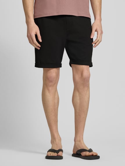 Männermodel trägt schwarze Shorts mit elastischem Bund und Gesäßtasche von MCNEAL, Material-Mix mit Viskose-Anteil, Regular-Fit, Nahaufnahme Oberschenkel.