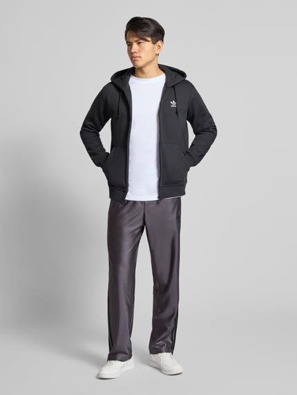 Mannelijk model draagt Jogpants met Label-Stitching model 'FIREBIRD' van adidas Originals, regular fit, elastische tailleband, full body frontaal.
