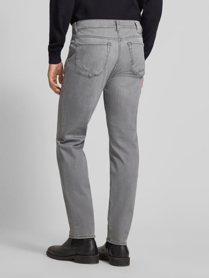 Mężczyzna prezentuje Straight Fit Jeans mit 5-Pocket-Design Modell 'Chuck' od Brax, mieszanka bawełny, prosty krój, szara kolorystyka, zapięcie na guzik i zamek, tylna perspektywa całej sylwetki.
