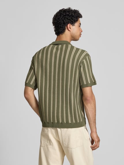 Męski model nosi Regular Fit Strick-Poloshirt Modell 'POUL' od Redefined Rebel z mieszanki bawełny, zielony z kremowymi paskami, krój regular fit, listwa guzikowa, długość tyłu w rozmiarze M: 66 cm, całkowity widok z tyłu.