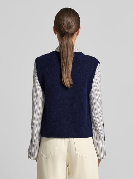 Frauenmodel trägt Regular Fit Cardigan aus elastischem Alpaka-Mix mit Knopfleiste von MOS MOSH in Dunkelblau, ärmellos, Rückenlänge 46 cm, Ganzkörperansicht Rückansicht.