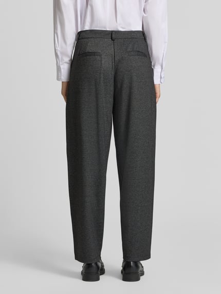 Frauenmodel trägt Bundfaltenhose mit seitlicher Eingrifftasche von Soyaconcept in Melange-Optik, Viskosemix, 7/8-Länge, Ganzkörperansicht Rückansicht.