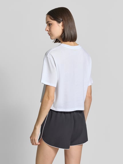 Frauenmodel trägt Relaxed Fit T-Shirt aus Baumwoll-Mix von Fabletics, weiß, Rundhalsausschnitt, überschnittene Schultern, Kurzarm, Rückansicht, Rückenlänge bei Größe S 48 cm.