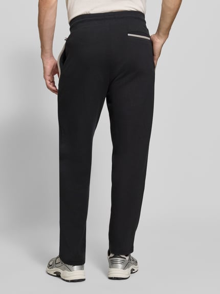 Männermodel trägt Regular Fit Sweatpants aus Baumwoll-Mix Modell 'Sense Pants' von BOSS, dunkle Farbe, glatte Textur, Ganzkörperansicht Rückansicht. Herren Sweatpants von BOSS.