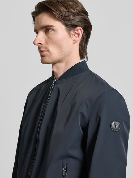 Männermodel trägt Regular Fit Jacke mit Stehkragen Modell 'Carlos' von JOOP! Collection, dunkelblau, Nahaufnahme Oberkörper. Elastischer Material-Mix, Reißverschluss, Eingrifftaschen, elastische Abschlüsse.