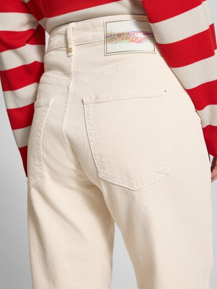 Frauenmodel trägt Baggy Fit Jeans aus Baumwoll-Mix von MAC in Beige mit Gesäßtaschen, Nietenbesatz und rückseitigem Label-Patch, Nahaufnahme Rückansicht.