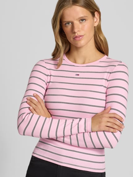 Frauenmodel trägt Slim Fit Langarmshirt aus Baumwoll-Mix von Tommy Jeans, rosa mit weißen und schwarzen Streifen, Nahaufnahme Oberkörper, Damen Langarmshirt von Tommy Jeans