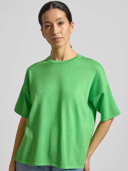 Frauenmodel trägt Relaxed Fit Shirt aus Viskose-Mix Modell 'LULS' von ICHI in Grün, weiche Textur, Rundhalsausschnitt, Nahaufnahme Oberkörper.