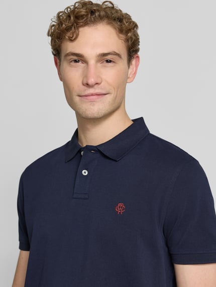 Männermodel trägt Regular Fit Poloshirt mit Label-Stitching von MCNEAL aus Reine Baumwolle, Knopfleiste, Nahaufnahme Oberkörper.