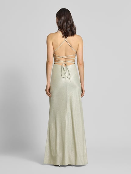 Vrouwenmodel draagt Abendkleid in Glitzer-Optik van Unique, licht glinsterend materiaal, open rug, vetersluiting, spaghetti bandjes, ruglengte 137 cm, borstwijdte 28 cm, geheel in crème tint, Ganzkörperansicht Rückansicht.