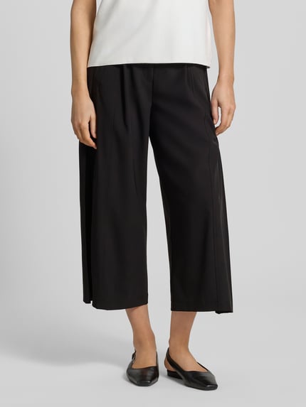 Vrouwenmodel draagt Regular Fit Barrel Leg broek met materiaalgelijke riem model 'CELESTE' van Cambio, look: effen, regular fit, high waist, riemlussen, plooien, sluiting: haak- en ritssluiting, zij-steekzakken, achterzakken, materiaalverwerking: satijn, kleur zwart, textuur glad, cropped lengte. Ganzkörperansicht van voren.