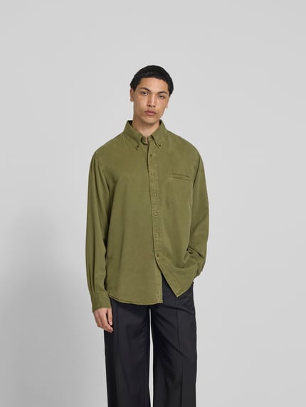 Męski model nosi Freizeithemd aus reinem Lyocell od Filippa K, oliwkowozielony, luźny krój, kieszeń na piersi, kołnierzyk button-down, długie rękawy, długość tyłu w rozmiarze 50: 72 cm, szerokość w rozmiarze 50: 48 cm, długość rękawa w rozmiarze 50: 70 cm, widok całej sylwetki z przodu.
