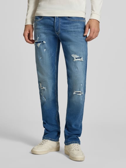 Männermodel trägt Straight Fit Jeans im Destroyed-Look Modell 'Grover' von Replay, hellblaue Denim-Struktur, Ganzkörperansicht von vorne, Baumwoll-Mix mit Stretch-Anteil.