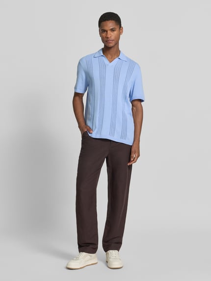 Männermodel trägt Relaxed Fit Poloshirt aus reiner Baumwolle von Armedangels in Optik: Unifarben, Feinstrick, Ganzkörperansicht von vorne.