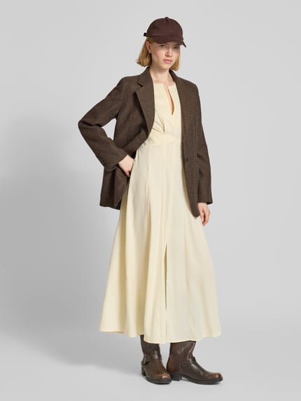 Frauenmodel trägt Midikleid mit V-Ausschnitt Modell 'VIANNA' von Copenhagen Muse in Creme, taillierter Schnitt, Drapierungen, Ganzkörperansicht von vorne.