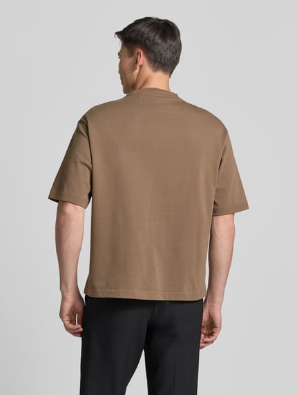 Męskimodel nosi Relaxed Fit T-Shirt aus reiner Baumwolle Modell 'ASPEN' od SELECTED HOMME, jednolity brązowy, gładka tekstura, całkowity widok z tyłu.