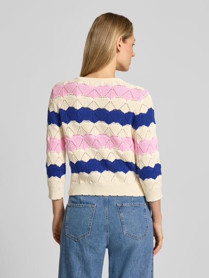 Frauenmodel trägt Strickjacke mit Knopfleiste und aufgesetzten Taschen von Rich & Royal, gestreiftes Muster in Creme, Rosa und Blau, reine Baumwolle, gerader Schnitt, Rückenlänge 48 cm, Ärmellänge 44 cm, Ganzkörperansicht Rückansicht.