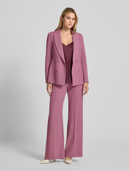 Vrouwenmodel draagt blazer met dubbele knoopsluiting van Rinascimento, Reverskraag, getailleerde pasvorm, paspelzakken, ruglengte maat S 64 cm, volledige lichaamsvoorzijde