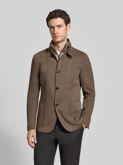 Männermodel trägt Slim Fit Sakko mit Woll-Anteil Modell 'Hypetar' von JOOP! COLLECTION in Braun, feine Struktur, Ganzkörperansicht von vorne.