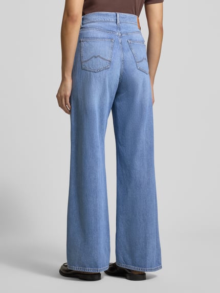 Kobiece modelka nosi luźne niebieskie spodnie Jeans mit 5-Pocket-Design Modell 'Luise' od Mustang, widok całej sylwetki od tyłu, bawełniany miks z modalem i lyocellem.