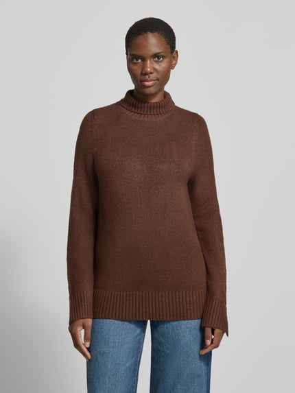 Frauenmodel trägt Rollkragenpullover mit breiten Rippabschlüssen von Jake*s Casual in Uni-Strickoptik, Regular Fit, Longline-Länge, Langarm, Rippabschlüsse, Ganzkörperansicht von vorne.