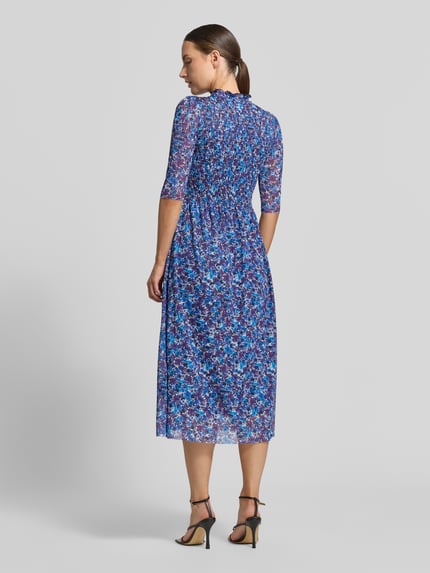 Frauenmodel trägt Midikleid mit Smok-Detail von Rich & Royal, blauer floraler Allover-Print, tailliert, 1/2-Arm, Rückansicht, Ganzkörperansicht.