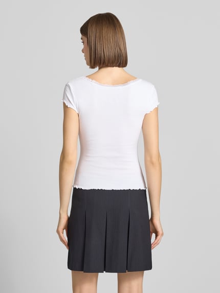 Kobiece modelka ma na sobie Slim Fit T-Shirt aus Viskose-Mix mit Spitzenbesatz od Review, biały, mieszanka wiskozy, krój slim fit, obszycie koronką, okrągły dekolt, długość tyłu w rozmiarze S: 51 cm, widok całej sylwetki z tyłu.