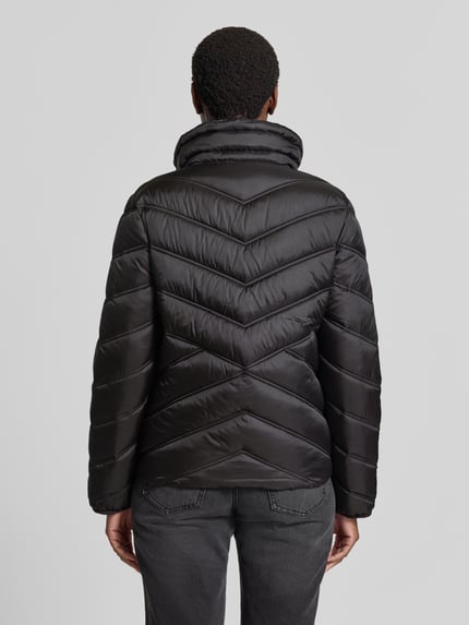 Frauenmodel trägt Steppjacke mit Stehkragen und Reißverschlusstaschen von Christian Berg Woman Selection, schwarze Farbe, glatte Struktur, leicht glänzend, Rückenlänge 61 cm, Schulterbreite 42 cm, Brustweite 51 cm, Ärmel 58 cm, Ganzkörperansicht Rückansicht.