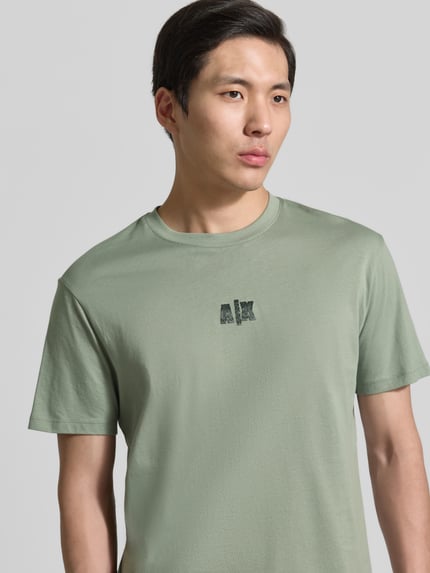 Männermodel trägt T-shirt mit logo en ronde hals van ARMANI EXCHANGE, puur katoen, regular fit, ruglengte maat M 82 cm, Nahaufnahme Oberkörper.